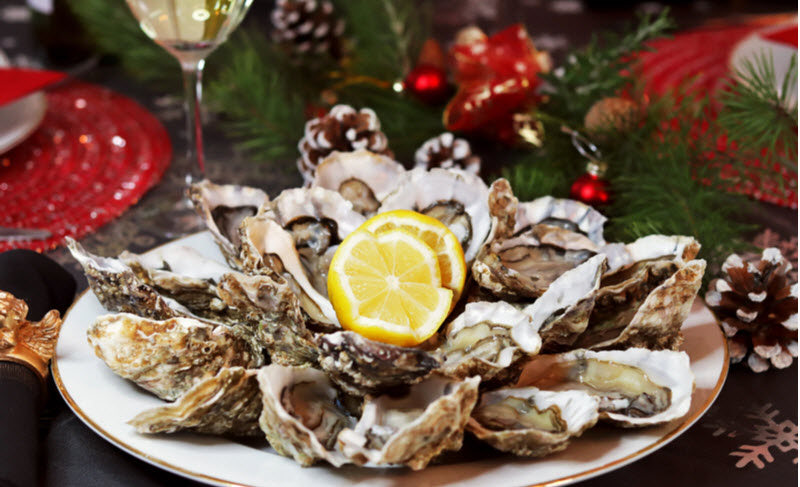 Oysters with lemon on a white dish on a table with a festive decor